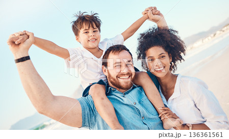 Mother, father and a child happy at the beach while on a vacation, holiday or adventure. A woman, man and kid on shoulders while together outdoor for summer fun and travel with multiracial family 136361561