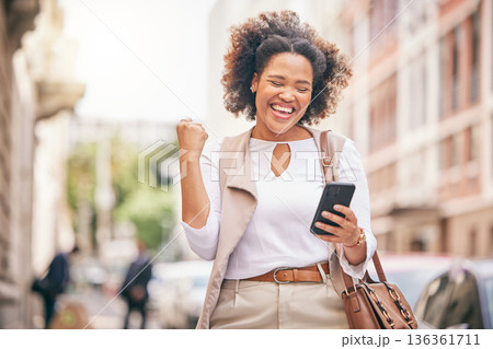 Happy woman, phone and city in celebration for winning, bonus promotion or outdoor sale discount. Excited female person with fist pump in happiness on mobile smartphone for good news in an urban town Happy woman, phone and city in celebration for winning, bonus promotion or outdoor sale discount. Excited female person with fist pump in happiness on mobile smartphone for good news in an urban town 136361711