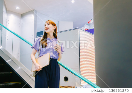 エスカレーターに乗る女性 136361870