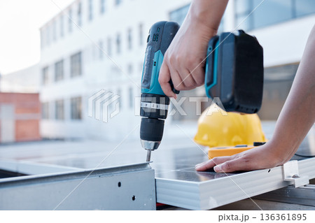 Solar panels, hands and electrician with power drill for engineering, grid and building maintenance in city. Closeup of technician, construction tools and upgrade of photovoltaic system on rooftop 136361895