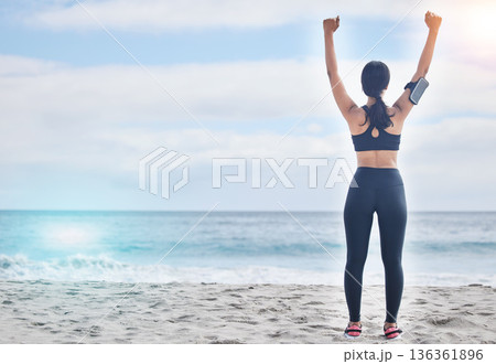 Fitness, celebration and woman with arms up at beach, mockup and winning achievement in nature. Ocean, goals and exercise girl for workout motivation, victory and blue sky with waves in natural space 136361896