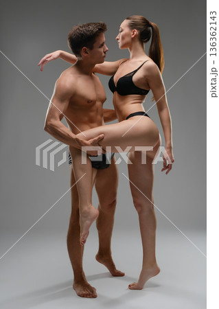 Athletic couple in black underwear in a passionate, dance-like embrace. 136362143