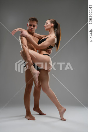 Athletic couple in a passionate contemporary dance pose against a gray background. 136362145