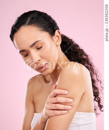 Woman, injury and arm pain with health problem or muscle tension in pink studio background. Joint pain, girl and self care for arthritis for wellness with fist aid or physio therapy for body fatigue. 136362208