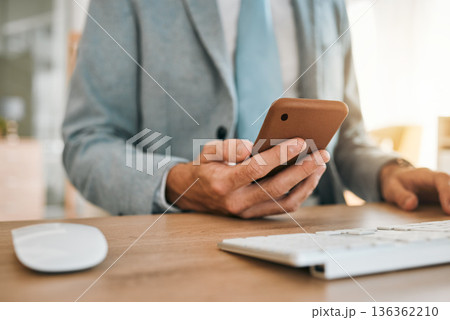 Business man, hands and phone app at desk with networking, text and online communication. Computer, mobile message and social media browse in a office and workplace with contact and typing at company 136362210