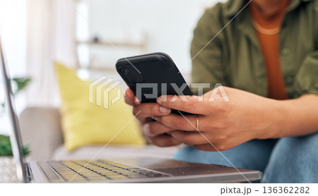 Hands of woman on sofa with phone, laptop and typing for remote work, research and documents for online job. Internet, networking and home office, freelancer on couch with cellphone and computer. Hands of woman on sofa with phone, laptop and typing for remote work, research and documents for online job. Internet, networking and home office, freelancer on couch with cellphone and computer. 136362282