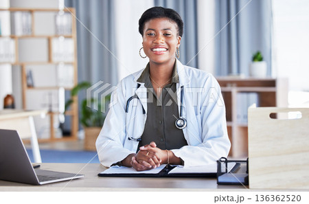 Black woman, portrait and doctor in office for medical services, advice and consulting in clinic. Happy female therapist, healthcare worker and consultant at desk in hospital for wellness management Black woman, portrait and doctor in office for medical services, advice and consulting in clinic. Happy female therapist, healthcare worker and consultant at desk in hospital for wellness management 136362520