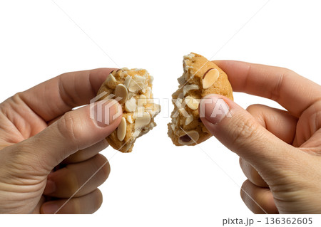 Hands breaking a crisp almond cookie or biscotti, creating a satisfying snap. Perfect for coffee break, snack time, and homemade baking concepts Hands breaking a crisp almond cookie or biscotti, creating a satisfying snap. Perfect for coffee break, snack time, and homemade baking concepts 136362605