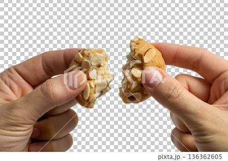 Hands breaking a crisp almond cookie or biscotti, creating a satisfying snap. Perfect for coffee break, snack time, and homemade baking concepts Hands breaking a crisp almond cookie or biscotti, creating a satisfying snap. Perfect for coffee break, snack time, and homemade baking concepts 136362605