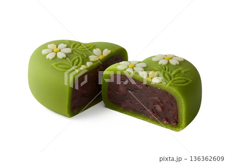 Heart-shaped green mochi filled with red bean paste, decorated with a delicate floral petal, perfect for japanese sweets and valentine's day 136362609