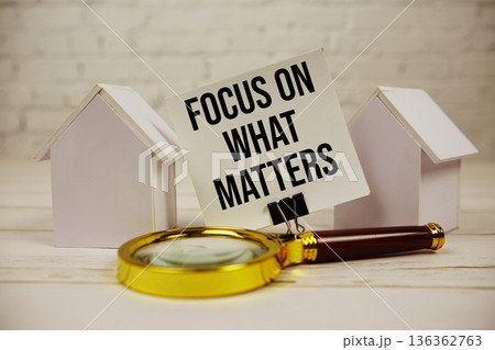 Focus On What Matters with magnifying glass and house model on wooden background 136362763
