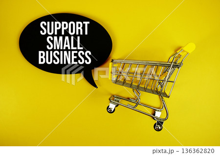 Support Small Business text with trolley shopping cart on yellow background 136362820