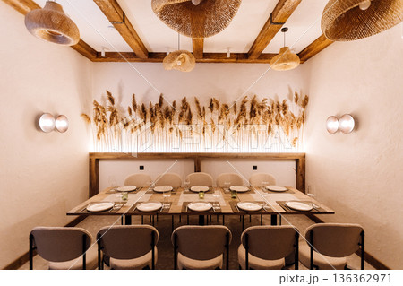 Cozy private dining room with rattan pendants and pampas decor, set table 136362971