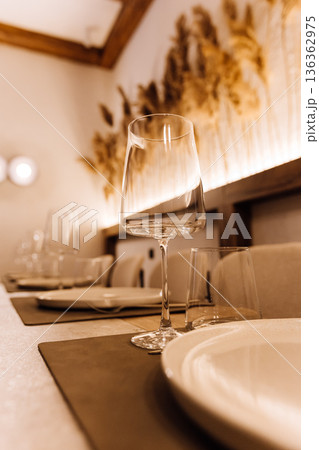 Close up wine glass on elegant dining table with warm ambient restaurant light Close up wine glass on elegant dining table with warm ambient restaurant light 136362975
