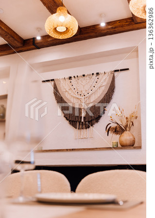 Boho fireplace mantel with macrame wall hanging, candles and dried flowers 136362986