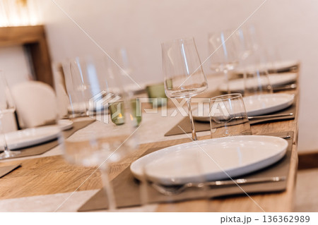 Wine glass on set restaurant table with warm candlelight and pampas decor 136362989