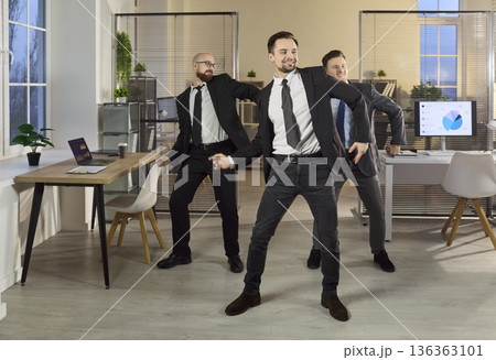 Office team of businessmen dancing, celebrating success and positive energy Office team of businessmen dancing, celebrating success and positive energy 136363101