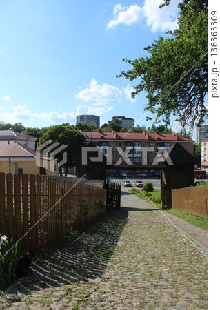 Cobblestone road between a wooden fence 136363309