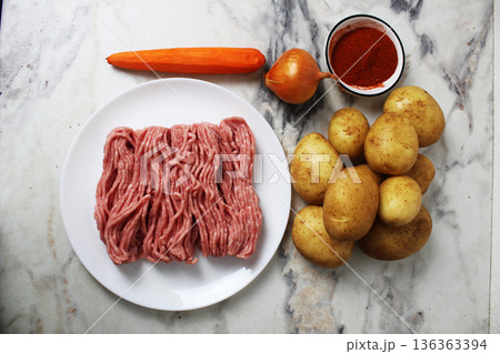 Products for making potato pancakes, sorcerers, meat, potatoes, carrots, onions, seasoning, top view 136363394