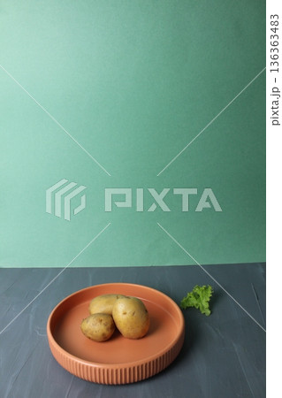 Potatoes on a plate. The concept of vegetarianism harvest Potatoes on a plate. The concept of vegetarianism harvest 136363483