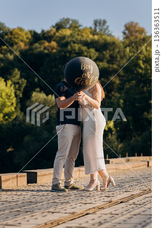 Couple holding Boy or Girl balloon at gender reveal, expecting baby outdoors Couple holding Boy or Girl balloon at gender reveal, expecting baby outdoors 136363511
