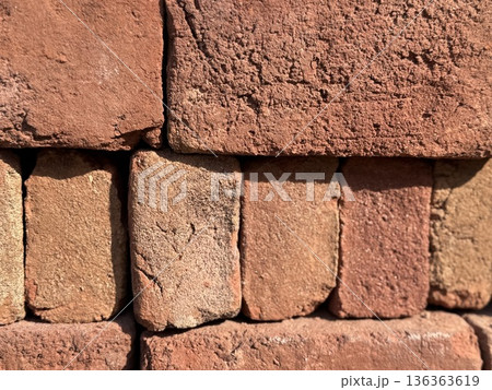 Brown brick wall texture with rough surfaces, perfect for architectural background use 136363619
