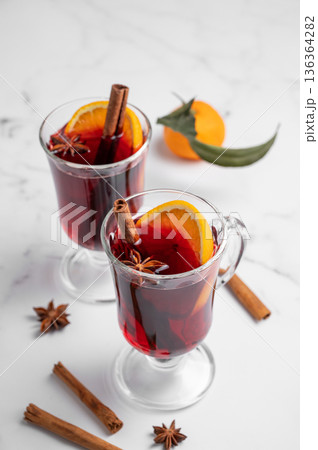 Two glasses of mulled wine, orange, cinnamon, and star anise on a marble background 136364282