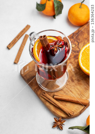 Glass of mulled wine, orange, cinnamon, and star anise on a wooden board 136364283