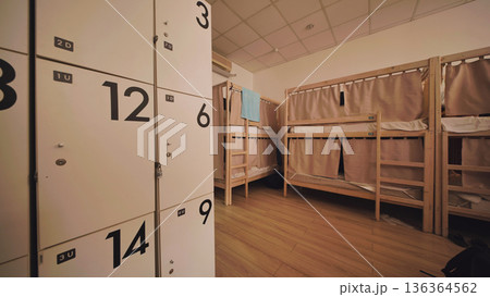 Hostel dormitory interior with modern bunk beds and secure lockers for budget travelers 136364562