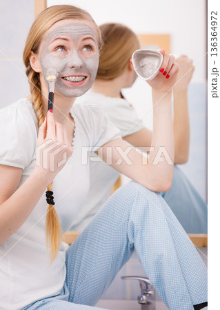 Woman with grey clay mud mask on her face Woman with grey clay mud mask on her face 136364972