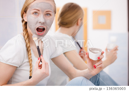 Woman with grey clay mud mask on her face 136365003