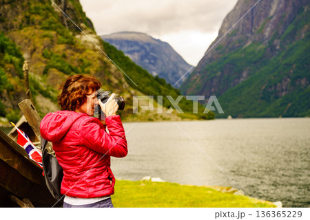 Tourist with camera near old viking boat, Norway Tourist with camera near old viking boat, Norway 136365229