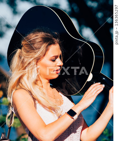 Blonde woman with acoustic guitar on seaside 136365297
