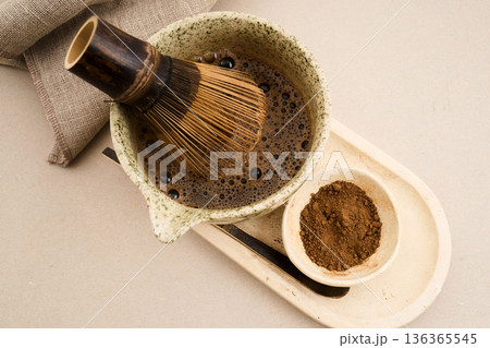 Preparing hojicha tea in ceramic bowl with whisk Preparing hojicha tea in ceramic bowl with whisk 136365545