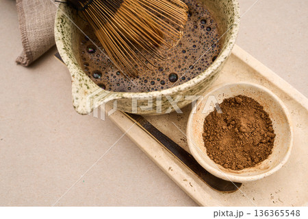 Whisking hojicha roasted green tea in ceramic bowl Whisking hojicha roasted green tea in ceramic bowl 136365548