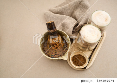 Preparing hojicha latte with whisk and roasted green tea 136365574