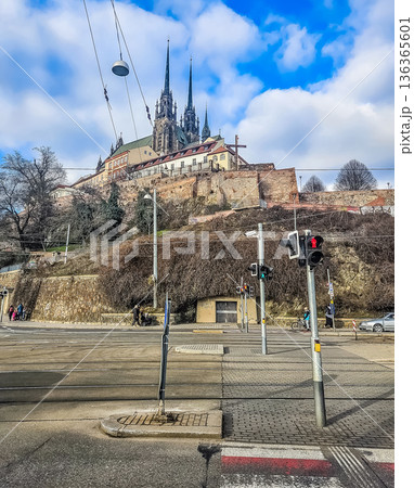 A low-angle street-level view of the majestic Gothic Cathedral of St. Peter and Paul, a dominant landmark of Brno, rising above the city on Petrov hill. High quality photo 136365601