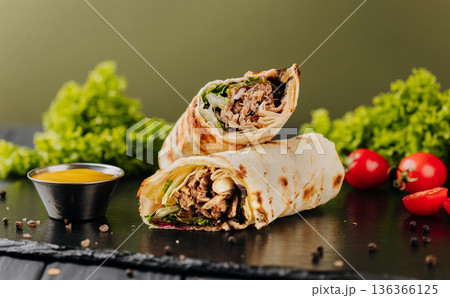 Grilled tuna tortilla wraps with greens, sauce and tomatoes on slate Grilled tuna tortilla wraps with greens, sauce and tomatoes on slate 136366125