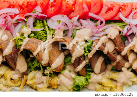 Open pork shawarma wrap with tomatoes, pickled onions and sauce, top view Open pork shawarma wrap with tomatoes, pickled onions and sauce, top view 136366129