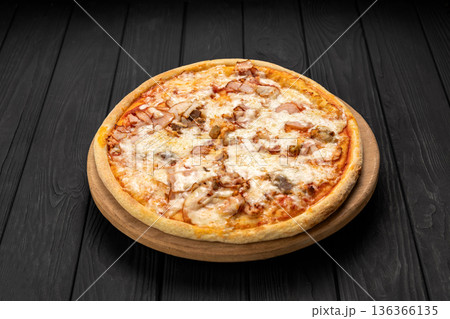 Cheesy chicken and mushroom pizza on wooden board, dark background 136366135