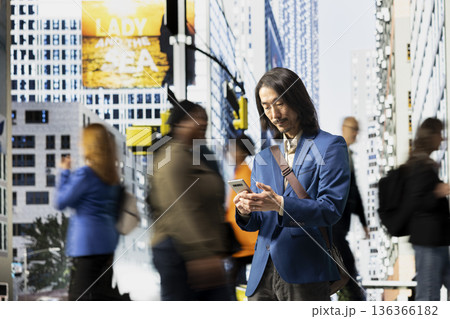 Asian modern professional browsing his smartphone apps in the street, walking along diverse pedestrian group downtown. Multicultural crowd of people and realistic urban environment. Asian modern professional browsing his smartphone apps in the street, walking along diverse pedestrian group downtown. Multicultural crowd of people and realistic urban environment. 136366182