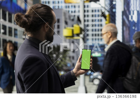 Vertical green screen on phone with male pedestrian walking along a busy downtown city street, showing community culture and the nonstop vibrant motion of metropolitan street life. 136366198
