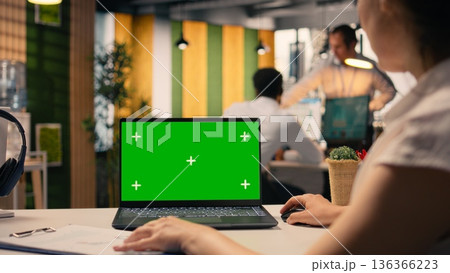 Green screen laptop, woman at desk, multinational company office, employee working, KPI metrics, and visual data. Analytics and insights, organizational planning, business intel. Green screen laptop, woman at desk, multinational company office, employee working, KPI metrics, and visual data. Analytics and insights, organizational planning, business intel. 136366223