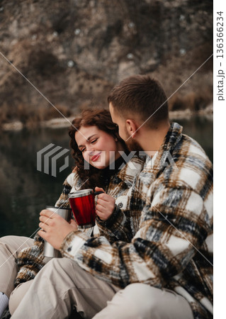 Couple enjoys warm drinks by the water while celebrating their relationship on Valentines Day Couple enjoys warm drinks by the water while celebrating their relationship on Valentines Day 136366234