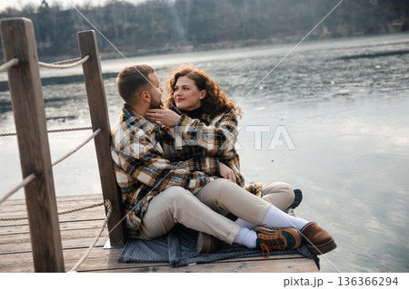 Couple sharing a moment on the dock by the lake on Valentines Day during a sunny afternoon in early spring Couple sharing a moment on the dock by the lake on Valentines Day during a sunny afternoon in early spring 136366294