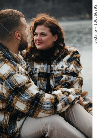 Couple enjoys each others company by the water on Valentines Day in cozy outfits, sharing moments of love and joy Couple enjoys each others company by the water on Valentines Day in cozy outfits, sharing moments of love and joy 136366295