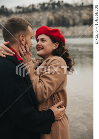 Couple enjoys a romantic moment by the water on Valentines Day in winter Couple enjoys a romantic moment by the water on Valentines Day in winter 136366308