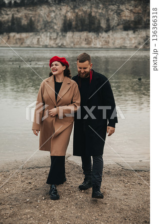Couple walks together by the water on Valentines Day enjoying their time together in a natural setting Couple walks together by the water on Valentines Day enjoying their time together in a natural setting 136366318