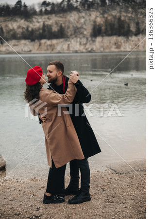 Couple dances together by the water on Valentines Day in a natural setting, celebrating love and connection 136366325