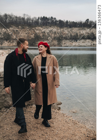 Couple walks hand in hand by the lake on Valentines Day enjoying their romantic moment together 136366473